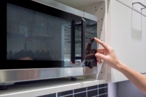 hand-touching-a-microwave-with-large-display